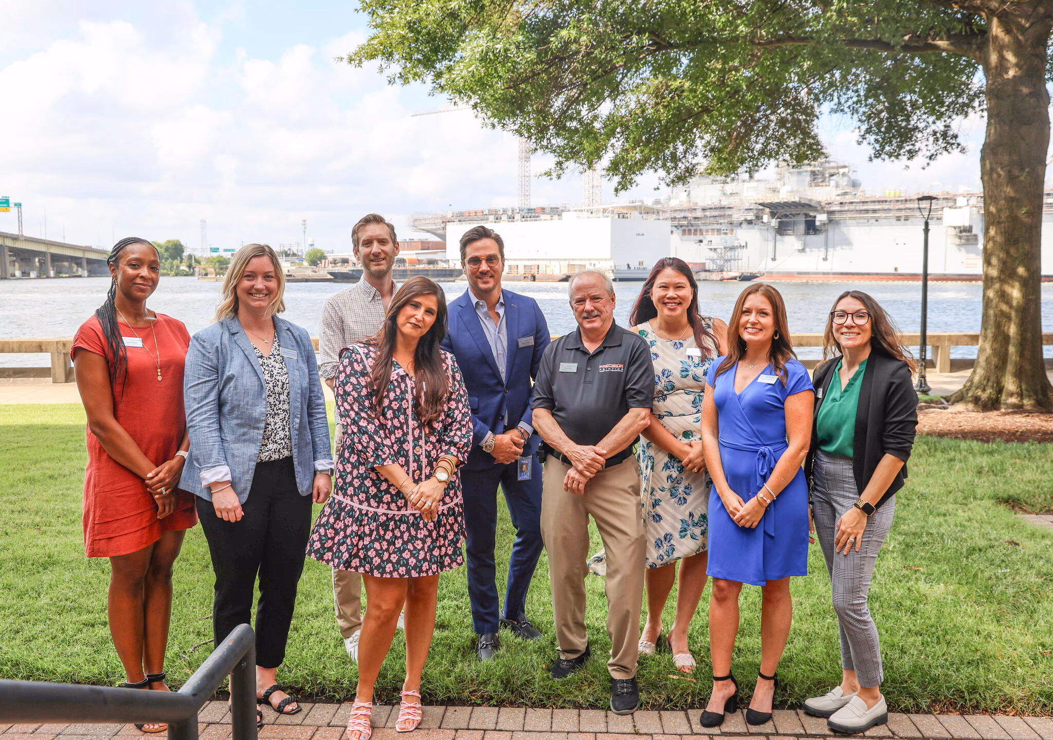 Group of diverse professionals posing outdoors by the waterfront in virginia, showcasing community collaboration and engagement in AI initiatives supported by AI Forward.